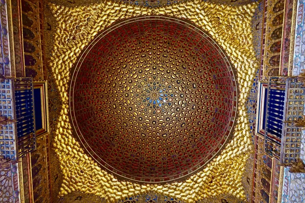 Low angle photo of red and yellow dome roof. A good example of Islamic art.