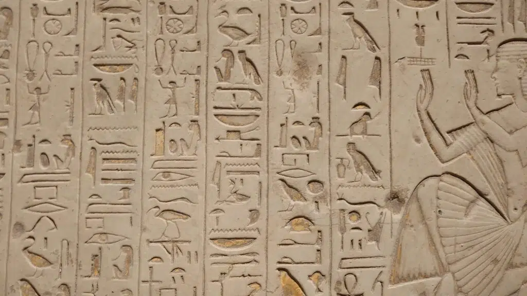 a close up of a wall with egyptian writing on it